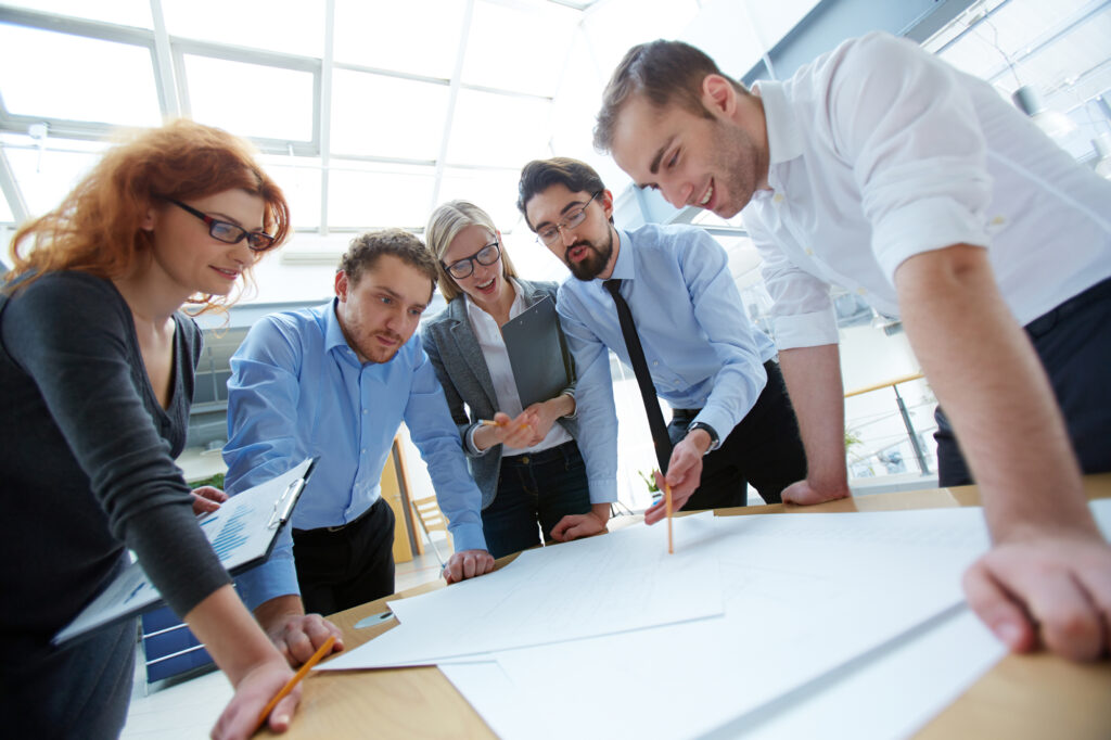 Stockphoto: a group of five discussing plans on a desk